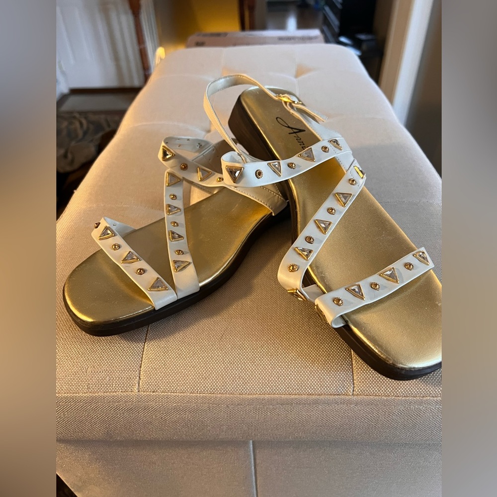 White sandals with gold embellishments